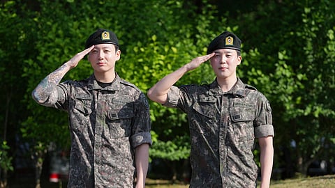 K-pop band BTS members Jimin, right, and Jung Kook salute after being discharged from a mandatory military service in Yeoncheon, South Korea, Wednesday