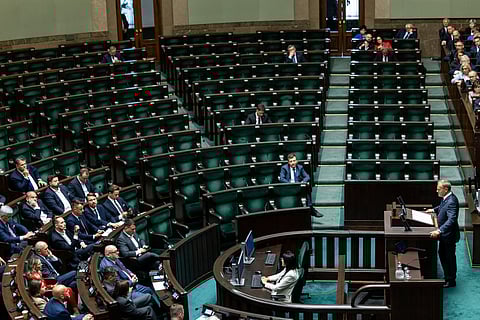 Poland's Prime Minister Donald Tusk speaks in Parliament as the seats of opposition Law and Justice (PiS) party MPs are empty in the background prior to the vote of confidence for his cabinet in Warsaw on June 11, 2025