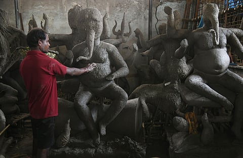 A artist shaping clay Ganesh idols at a workshop in Hyberabad