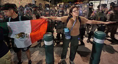 Anti ICE protesters gather near the Alamo as Texas state troopers keep watch in downtown San Antonio, Wednesday, June 11, 2025. 