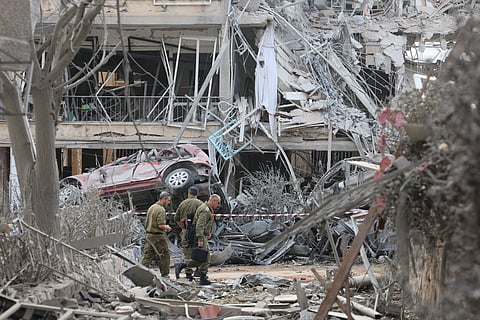Damaged buildings and vehicles are seen in the Israeli city of Ramat Gan near Tel Aviv on June 14, 2025, caused by the fall of a missile fired the day before by Iran. 