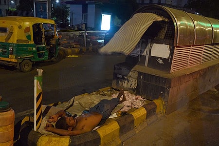 Homeless people sleeping on footpath. 