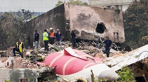 Officials inspect the site of Thursday's Air India plane crash on the roof of a building in Ahmedabad, Friday, June 13, 2025.
