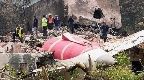 Officials inspect the site of Thursday's Air India plane crash on the roof of a building in Ahmedabad, Friday, June 13, 2025.
