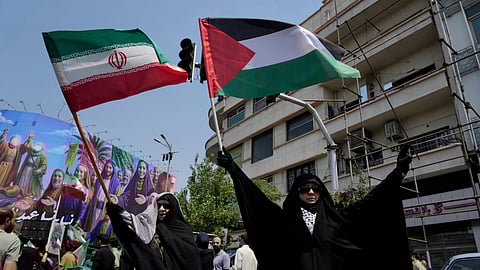 Iranian protesters hold up Iranian and Palestinian flags in an anti-Israeli gathering in Tehran, Iran, Friday, June 13, 2025.