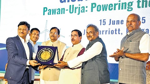 Energy Minister KJ George receives an award recognising the state’s achievement in wind power capacity from Union Minister for New and Renewable Energy Pralhad Joshi at the Global Wind Day programme in Bengaluru on Sunday.
