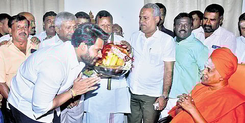 JDS youth wing president Nikhil Kumaraswamy seeks the blessings of Sri Siddalinga Swami at Siddaganga Mutt in Tumakuru on Monday 