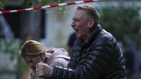 A father cries as his son is under the rubble of a multi-storey residential house destroyed by a Russian strike in Kyiv, Ukraine on Tuesday, June 17, 2025.