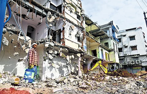 A worker oversees the demolition of residential and commercial  properties for the setting up of Airport Metro in Old City of Hyderabad