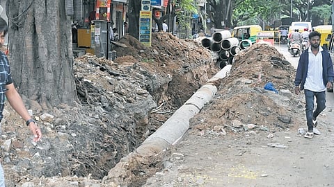 Pedestrians are forced to walk dangerously close to traffic, so as to avoid falling into the ditch dug by the BWSSB near Navarang Talkies in Rajajinagar