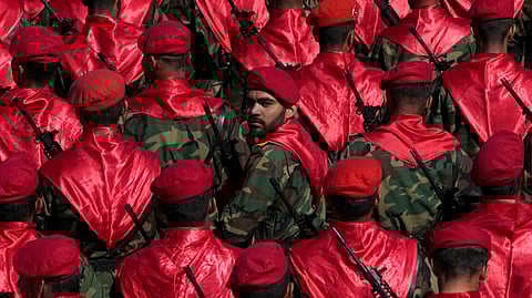 An Iranian army member looks back among others as they conclude their march during a parade commemorating National Army Day in front of the shrine of the late revolutionary founder Ayatollah Khomeini, just outside Tehran, Iran, on Friday, April 18, 2025.