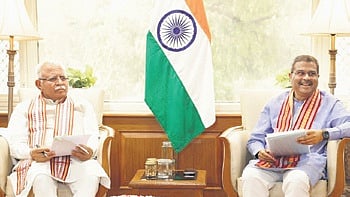 Dharmendra Pradhan with Manohar Lal Khattar in New Delhi on Monday