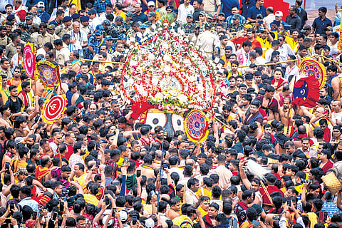 Servitors bring Lord Jagannath in the ceremonial ‘pahandi bije’ to his chariot during Rath Yatra, in Puri on Friday.