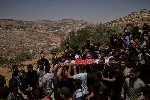 Mourners carry the bodies of three Palestinians who were killed on Wednesday when Jewish settlers stormed the West Bank village of Kafr Malik, Thursday, June 26, 2025.