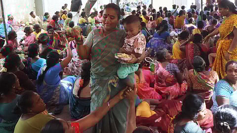Sanitation workers in Madurai representing all unions have been on strike since Monday demanding the fulfillment of various demands. Today, a woman worker was seen participating in the protest while feeding breakfast to child.