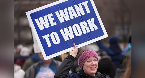 In this photo from Feb. 28, 2025, Katy Frank, a former computer scientist at the NOAA Great Lakes Environmental Research Lab, who lost her job Thursday, protests outside the John D. Dingell Veterans Affairs Medical Center in Detroit.