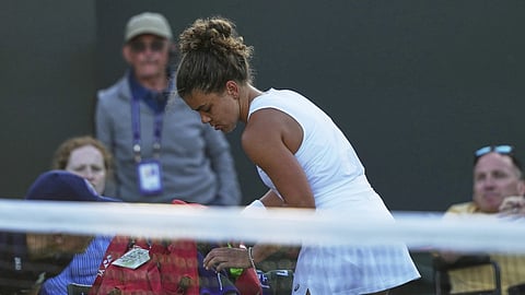 Jasmine Paolini of Italy packs up to leave the court after losing to Russia's Kamilla Rakhimova during their second round women's singles  match at the Wimbledon Tennis Championships in London, Wednesday, July 2, 2025
