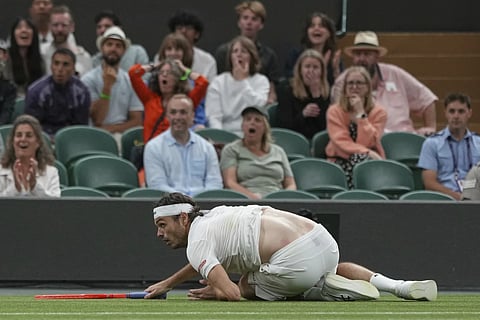 Taylor Fritz of the US falls after he dived to return to Gabriel Diallo of Canada during their second round men's singles match at the Wimbledon Tennis Championships in London, Wednesday, July 2, 2025.