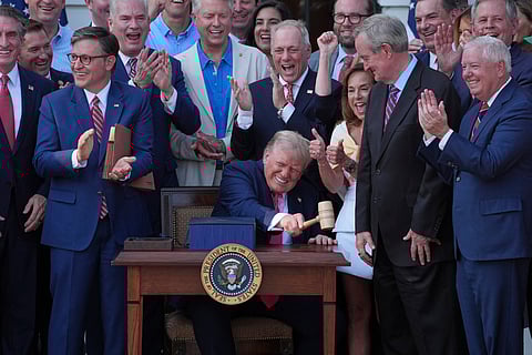 President Donald Trump bangs a gavel presented to him by House Speaker Mike Johnson of La., after he signed his signature bill of tax breaks and spending cuts at the White House, Friday, July 4, 2025, in Washington.