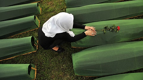 A Bosnian Muslim woman, survivor of Srebrenica 1995 massacre, mourns over body casket of her relative, at memorial cemetery in village of Potocarion near Eastern-Bosnian town of Srebrenica.