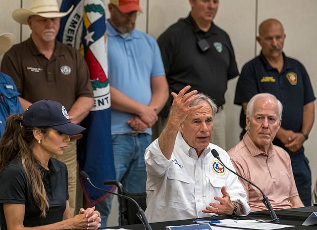 Texas Gov. Greg Abbott, center, speaks to media during a press conference as Homeland Security Secretary Kristi Noem, left, and Sen. John Cornyn listen, after recent flooding along the Guadalupe River during a press conference on Saturday, July 5, 2025, in Kerrville, Texas.