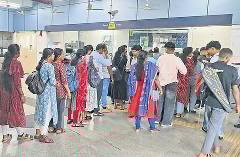 Commuters standing in queue to buy tickets at the Kaloor metro station on Tuesday. 