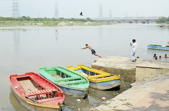 A man dives into the swollen river.