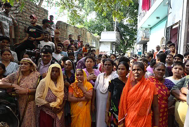 Local crowd at the spot where double murder of a woman and an infant took place at Civil Lines area, in New Delhi on Tuesday