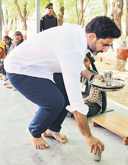 HRD Minister Nara Lokesh removing the plate of his father Chandrababu Naidu after having lunch with students at Kothacheruvu ZP High School on Thursday | Express