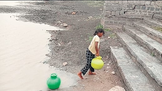 A girl fills unclean water from the lake.