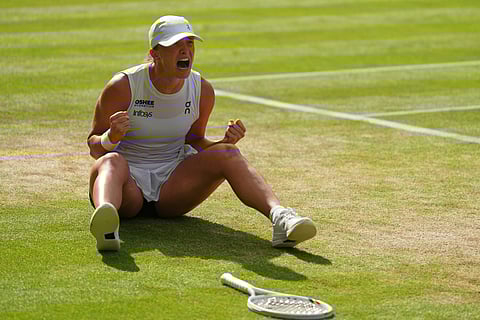 Italy's Jannik Sinner celebrates with the winner's trophy following his victory against Spain's Carlos Alcaraz at the end of their men's singles final tennis match on the fourteenth day of the 2025 Wimbledon Championships at The All England Lawn Tennis and Croquet Club in Wimbledon, southwest London, on July 13, 2025.