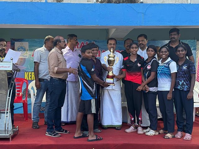 Members of the Thiruvananthapuram district team receiving the trophy from M Vijayakumar, honourary life president of State Aquatic Association