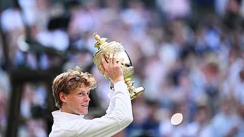Italy's Jannik Sinner celebrates with the winner's trophy following his victory against Spain's Carlos Alcaraz at the end of their men's singles final tennis match on the fourteenth day of the 2025 Wimbledon Championships at The All England Lawn Tennis and Croquet Club in Wimbledon, southwest London, on July 13, 2025.