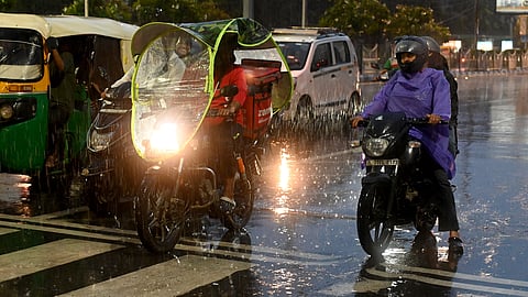 Commuters during rain in New Delhi on Sunday, July 13, 2025.