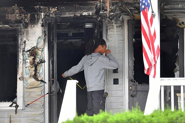 An investigator takes measurements Monday, July 14, 2025, near an entrance to the Gabriel House assisted living facility following a fire that started late Sunday, in Fall River, Mass.