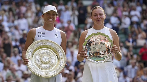 Poland's Iga Swiatek, left, celebrates with the trophy after beating Amanda Anisimova of the US., right, to win the women's singles final at the Wimbledon Tennis Championships in London, Saturday, July 12, 2025.