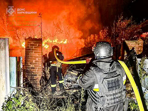 In this photo provided by the Ukrainian Emergency Service, firefighters try to put out a fire following a Russian attack in the Kharkiv region of Ukraine, Tuesday, July 15, 2025. 