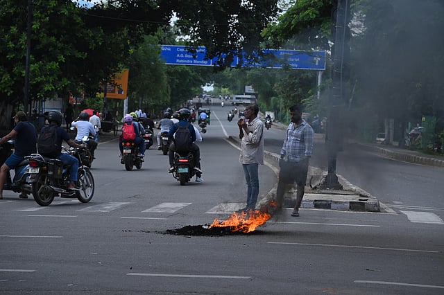 Congress workers burn tyres and block NH16 service road observing Odisha Bandh at Acharya Vihar in Bhubaneswar.