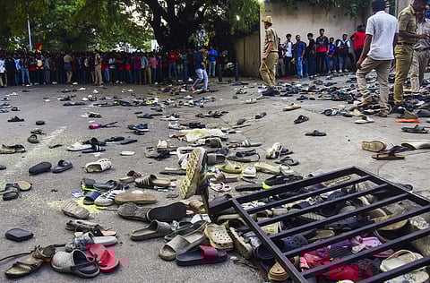 In this June 4, 2025 file photo, footwear lie on the ground outside the Chinnaswamy Stadium following a stampede during RCB's victory celebrations.