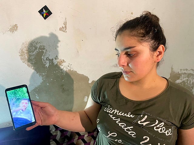 Druze woman Evelyn Azzam, 20, shows a picture of her husband, who was wounded in clashes between Syrian government forces and Druze militias in Sweida, during an interview with The Associated Press in the southern Damascus suburb of Jaramana, Wednesday, July 16, 2025.
