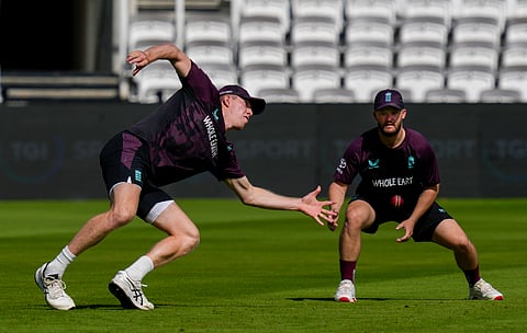 Zak Crawley reaches out to catch the ball at practice with teammate Ben Duckett