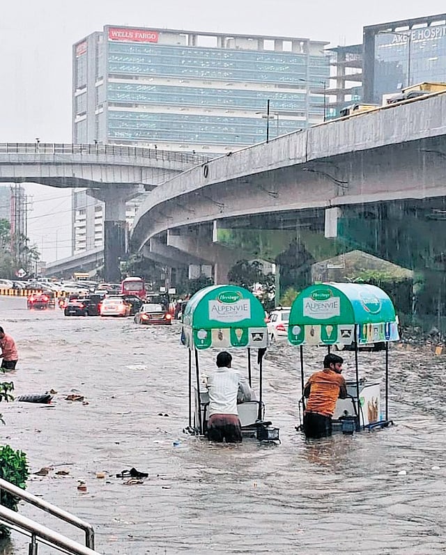 Ice cream vendors negotiate another waterlogged road at Gachibowli 