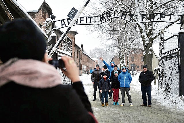 Beyond the gates, the Nazi camp stretches row upon row of barracks, once filled with human suffering
