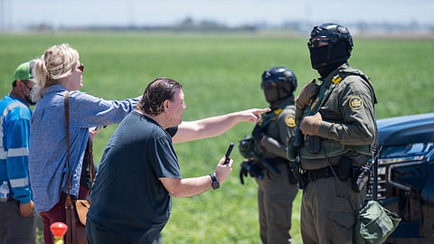People shout at federal immigration agents during a raid in the agriculture area of Camarillo, Calif., July 10, 2025.