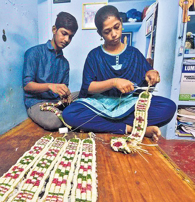 Vanitha knots oleander flowers to craft the Maanikka Maalai, a garland resembling gemstones