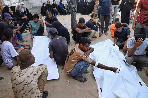 Relatives of Palestinians killed at an aid distribution center run by the Gaza Humanitarian Foundation, a U.S.-backed organization approved by Israel, mourn over their bodies during their funeral at Nasser Hospital in Khan Younis, southern Gaza Strip, Saturday, July 19, 2025.