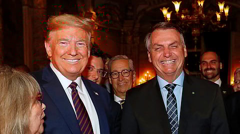 Brazil's President Jair Bolsonaro, right, stands with President Donald Trump during a dinner at Mar-a-Lago, Palm Beach, Fla., March 7, 2020. Bolsonaro's son, Eduardo is pictured in background on right.