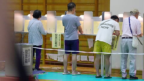 Voters fill in their ballots in the upper house election at a polling station Sunday, July 20, 2025, in Tokyo.