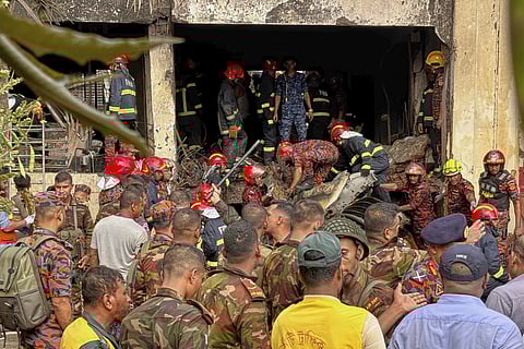 Firemen work at the site of a Bangladesh Air Force training aircraft that crashed into a school campus shortly after takeoff in Dhaka, Bangladesh, Monday, July 21, 2025. 
