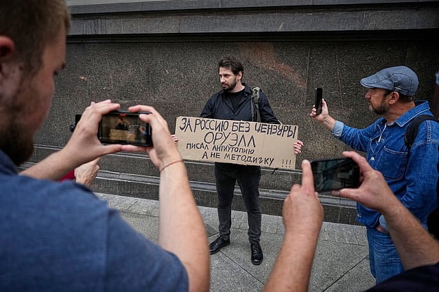 An activist holds a poster reading "For Russia without censorship. Orwell wrote a dystopia, not an instruction manual" during a picket against internet limitations in front of The State Duma, the lower house of the Russian Parliament. 
